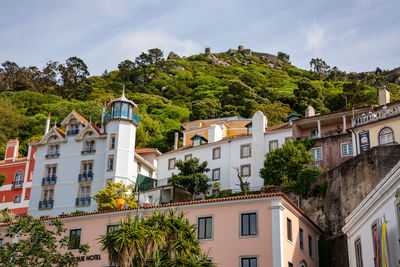 Houses in sintra with the view of the ruined castle of castelo dos mouros high above, portugal