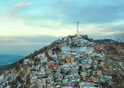 View of cityscape against cloudy sky