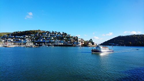 Scenic view of sea by buildings against blue sky