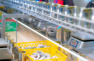 Canned fish factory. food industry. sardines in yellow plastic basket waiting for worker to fill 