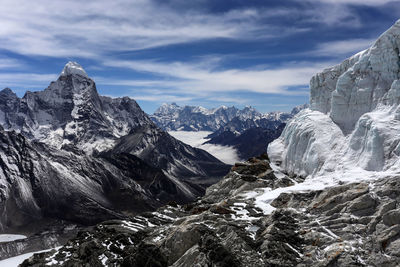 Scenic view of snow covered mountains against cloudy sky