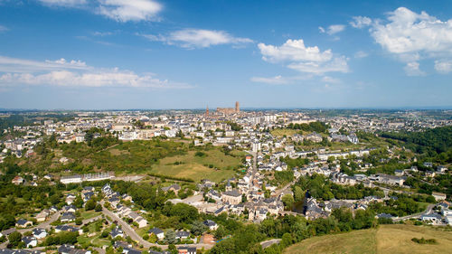 Aerial view of townscape by sea against sky