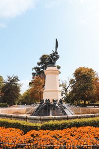 Statue in park against sky during autumn