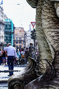 People on street amidst buildings in city