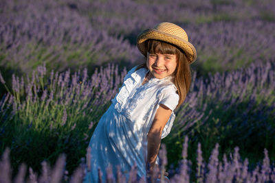 Woman standing by purple flowers on field