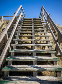 Low angle view of stairs against clear blue sky
