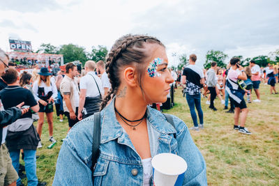 Young woman with drink looking away at party