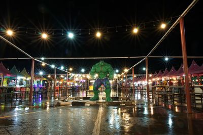 Reflection of man standing on wet glass during rainy season at night