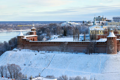 Snow covered houses and buildings against sky