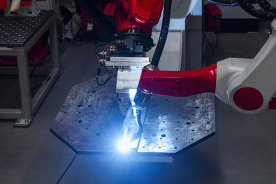 Close-up of automatic robotic arm welding metal in factory