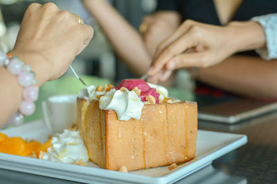 Eatting honey toast with red homemade ice cream and whipping cream topping in cafe and restaurant.