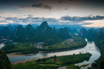 Scenic view of river and mountains against sky