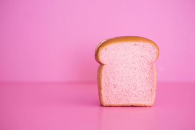 Close-up of cake on table against pink background