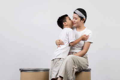 Rear view of couple sitting against white background