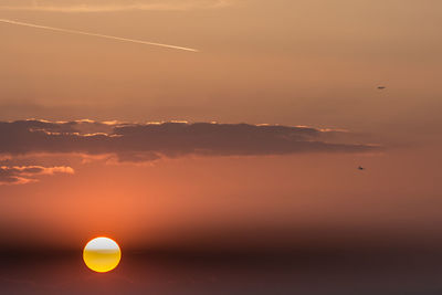 Scenic view of vapor trails in sky at sunset