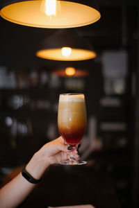 Close-up of hand holding frothy drink