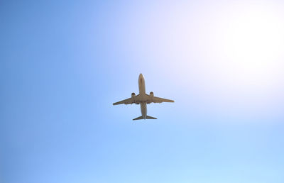 Low angle view of airplane against clear blue sky