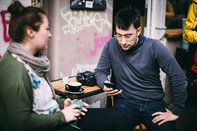 Man and woman using smart phone at home