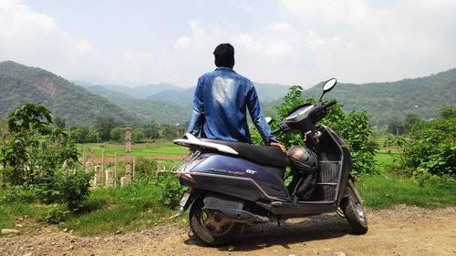 Rear view of man riding bicycle on mountain