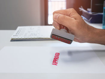 Close-up of man holding book on table