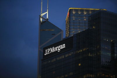 Illuminated text on skyscrapers against sky at night