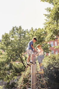 Child friends climbing net in park