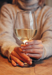Midsection of woman holding wineglass