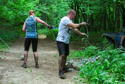 Full length of men standing in forest