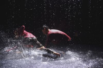 People swimming in water at night