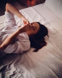 Portrait of young woman relaxing on bed at home