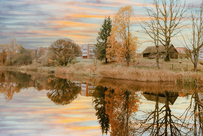 Scenic view of lake by buildings against sky