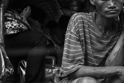 Midsection of man sitting outdoors