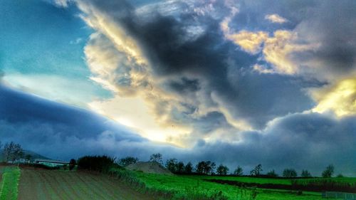 Scenic view of field against cloudy sky