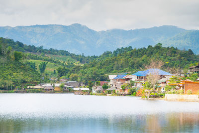 Buildings by mountains against sky