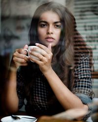 Portrait of young woman drinking coffee