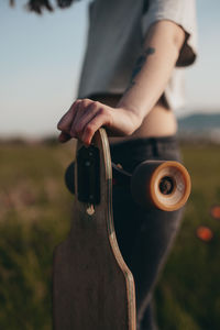 Detail of a girl leaning on a longboard. anonymous photography. faceless . sunny day .