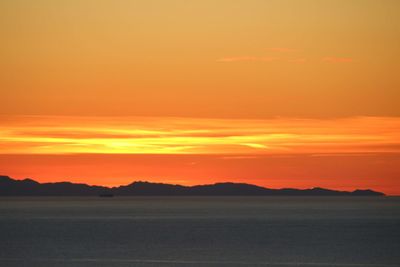 Scenic view of sea against romantic sky at sunset