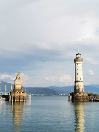 Lighthouse by sea against sky