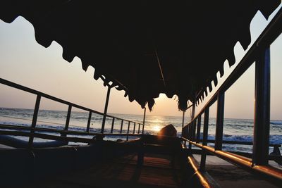 Silhouette woman on beach against clear sky during sunset