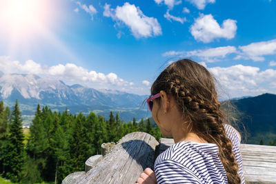 Girl hiking on beautiful summer day in alps mountains austria,  admire amazing view to mountain peak