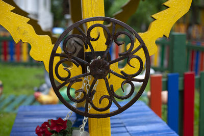 Close-up of yellow flower on metal structure