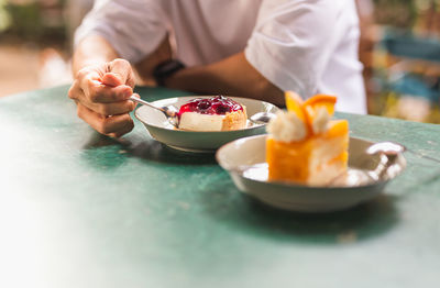 Midsection of woman having food on table