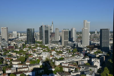 Aerial view of buildings in city against clear sky