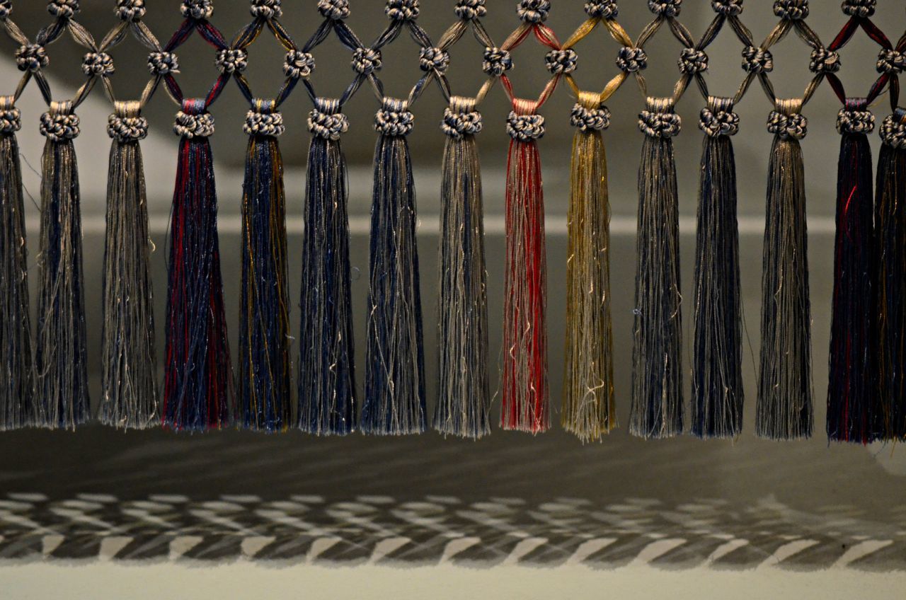 CLOSE-UP OF ROPES HANGING ON METAL