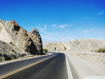 Road amidst rocks against sky