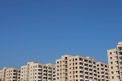 Low angle view of buildings against clear blue sky