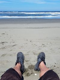 Low section of man standing on beach