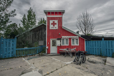 Wheelchair by first aid house against sky