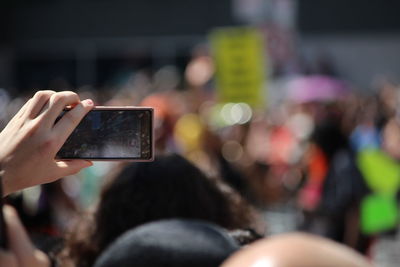 Cropped hand photographing though mobile phone