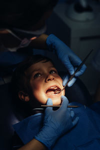 Dentist operating boy in medical clinic